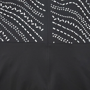 Detailed close-up of intricate silver rhinestone wave patterns on a black maxi dress
