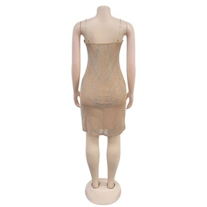 Detailansicht der silbernen Strasssteine und geometrischen Muster am beigen Kleid