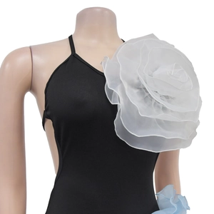 Detail of a black sleeveless dress featuring a large white mesh floral shoulder accent