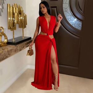 Detail of the high slit and twisted waist design on a red floor-length evening dress