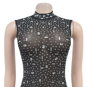 Detailed view of black sheer mesh dress with luxury rhinestone patterns and a high neckline