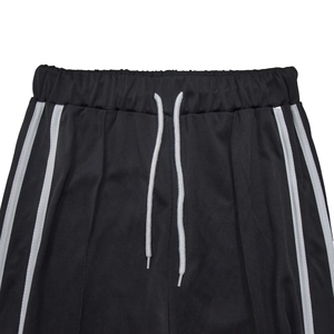 Détail du short de sport noir avec taille élastique et doubles bandes latérales blanches