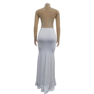 Close-up of the back detail on a white floor-length dress with silver rhinestones and zipper