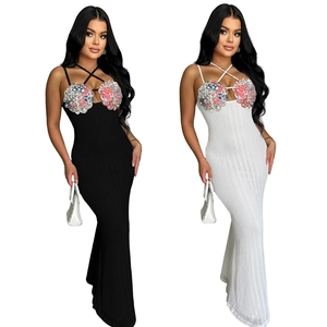 Detail of sequin floral appliques and cross halter straps on slim knit maxi dresses