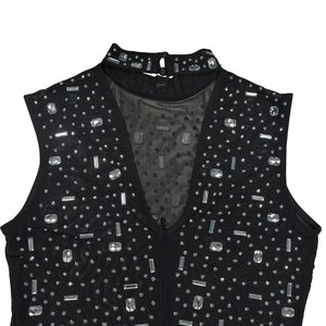 Detail of black sleeveless dress featuring rhinestone high neck and sheer mesh V-panel