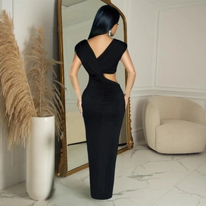 Détail de robe longue noire moulante avec dos nu et découpes élégantes à la taille