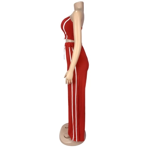 Vue latérale du haut court rouge sans manches et du pantalon avec bandes blanches