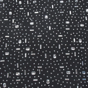 Detail of black fabric with intricate silver rhinestones and crystals on long dress