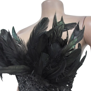 Macro detail of black sequins and iridescent feathers on a luxury sleeveless dress