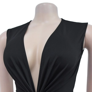 Detail view of deep V-neckline and pleated waist on black sleeveless knit dress