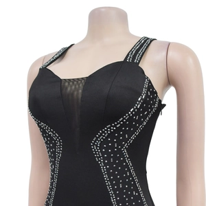 Détail de robe noire ajustée avec empiècements en maille V et strass argentés brillants
