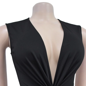 Detail of a black sleeveless dress showing the deep V-neckline and smooth fabric texture
