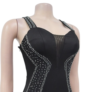 Détail de robe noire avec strass argentés et décolleté en V profond en maille transparente