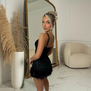 Detail showing high-quality sequins and soft black feather trim on a mini dress