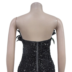 Detail of black sequined mini dress featuring feather side accents and back zipper closure