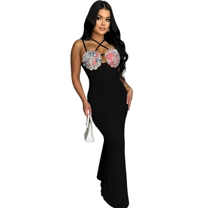 Detail of black rib-knit maxi dress featuring floral sequin patches and thin cross straps