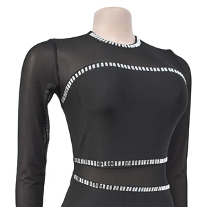 Detail of elegant black mesh dress featuring silver rhinestone trim on sheer sleeves
