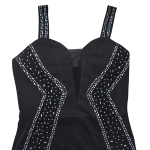 Détail de la robe noire à col en V avec strass argentés brillants et empiècement mesh