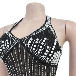 Detail of black mesh dress featuring intricate white pearls, rhinestones and sequins