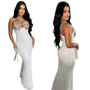 Close-up of white knit maxi dress with colorful sequins and criss-cross neckline straps