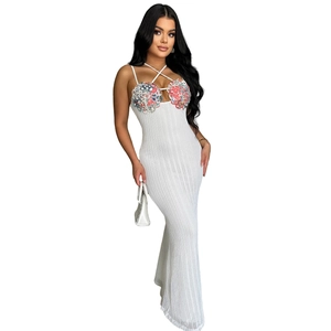 Close-up of white ribbed knit dress featuring halter neck and floral chest embroidery