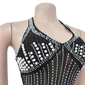 Detail of black halter dress featuring vertical sequins and decorative white pearls