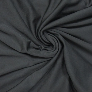 Close-up of soft black knitted fabric with a spiral fold texture and matte finish