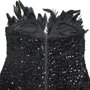Detail of black sequin dress featuring feather trim and a hidden back zipper closure