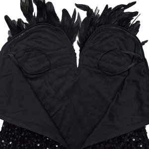 Detail of black sequined dress with ostrich feather trim and elegant V-neck stitching