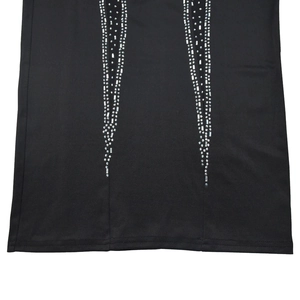 Gros plan détaillé des motifs en strass sur tissu noir avec couture à double aiguille
