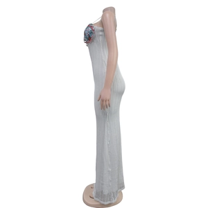 Detail of white knit maxi dress featuring vertical hollow texture and sequin bodice trim