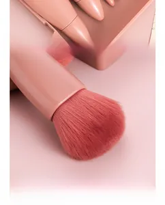 Macro detail of dusty rose makeup brush with dense soft bristles and matte handle