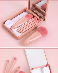 Macro view of 5-piece travel makeup brush set with mirror in a compact pink storage case