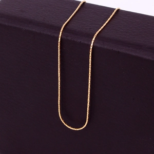Elegant gold 316L titanium steel knot chain necklace displayed on a textured box