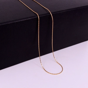 Close-up of thin golden stainless steel link chain with detailed rectangular links