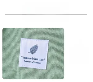 Detail of light green corduroy shopping bag featuring a minimalist leaf label patch