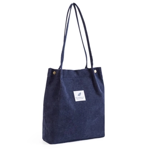 Navy corduroy tote bag with dual shoulder straps and square white label decoration
