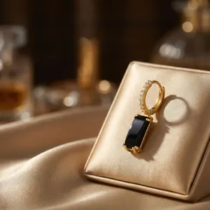 Detail view of 18K gold plated earrings featuring black agate and white zircon accents