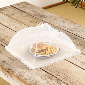 Close-up of a white lace folding food cover mesh protecting burgers on a wooden table