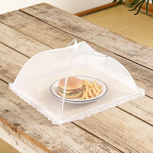 Foldable large mesh food cover with elegant lace trim protecting a meal on a wooden table