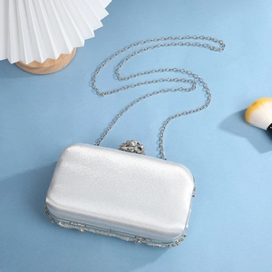 Silver satin evening clutch bag with rhinestone clasp and hanging pearl decorations