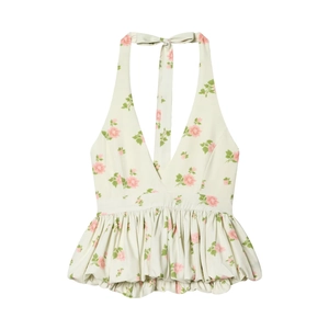 Floral halter top with V-neck, cinched waist, and flowy hem in cream and pink floral print