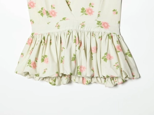 Detail of floral V-neck summer dress with high waist pleats and ruffle hem texture