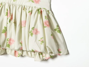 Detail of floral bubble hem dress with pink blossom print and pleated fabric texture