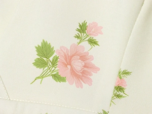 Close-up of floral print fabric detail featuring pink blossoms on beige background
