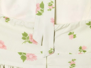 Detailed close-up of floral print cotton fabric with waist seam and strap quality