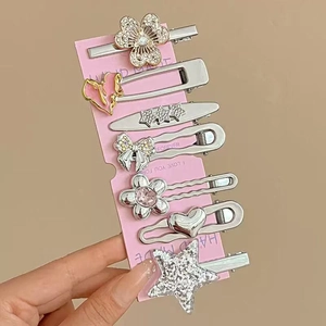 Détail d'un lot de 7 pinces à cheveux argentées et roses avec cœurs, étoiles et nœuds