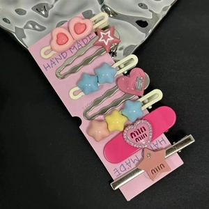 Détail de l'ensemble de barrettes métalliques pastel avec étoiles et motifs lettres