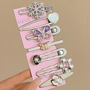 Gros plan d'un lot de 6 barrettes en métal avec bijoux roses et perles sur carte rose
