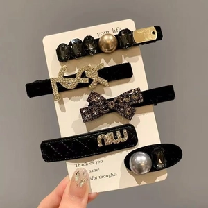 Gros plan sur un lot de 5 barrettes de luxe avec perles et strass sur carte